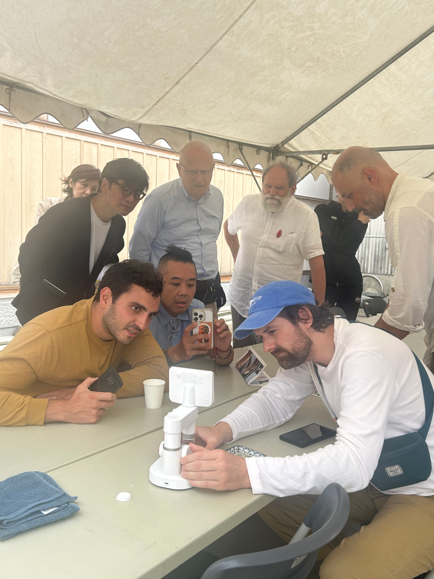 Guests and chefs gathered around a microscope during a tasting session at the festival