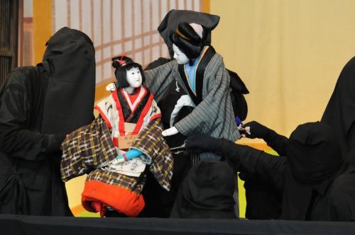 Puppeteers in black robes performing Imada ningyo joruri puppet theatre