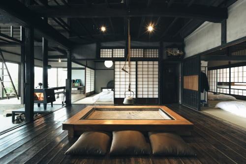 Interior of the kominka farm stay with a sunken hearth and dark timber floors